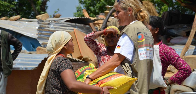 Eine Helferin von Aktion Deutschland Hilft spricht mit Frauen.